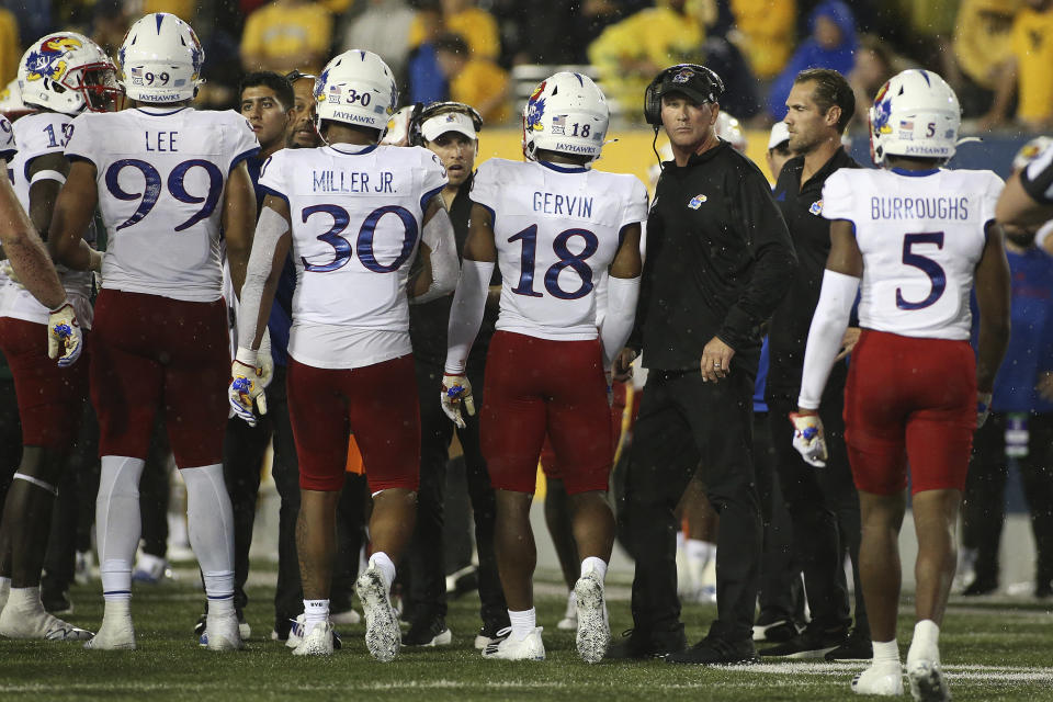 Kansas coach Lance Leipold, third from right, meets with his players during the second half of an NCAA college football game against West Virginia in Morgantown, W.Va., Saturday, Sept. 10, 2022. (AP Photo/Kathleen Batten)