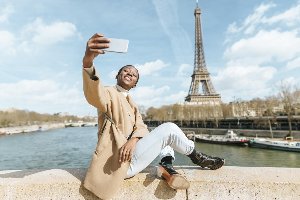 Woman sitting on bridge over the river Seine