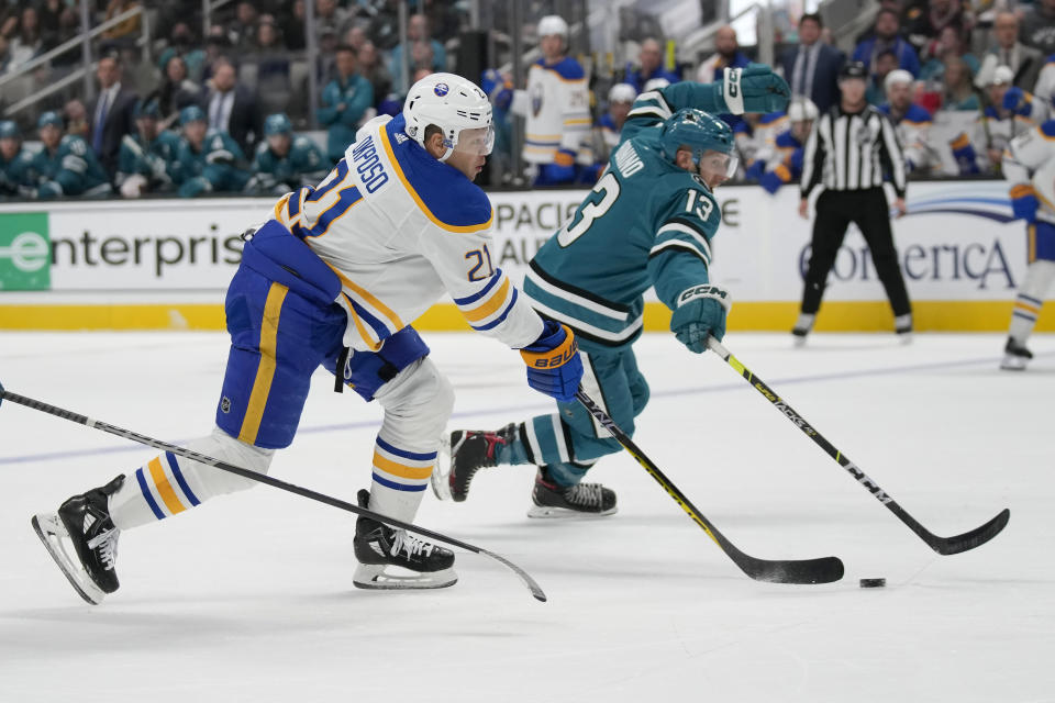 Buffalo Sabres right wing Kyle Okposo (21) skates with the puck next to San Jose Sharks center Nick Bonino (13) during the second period of an NHL hockey game in San Jose, Calif., Saturday, Feb. 18, 2023. (AP Photo/Jeff Chiu)