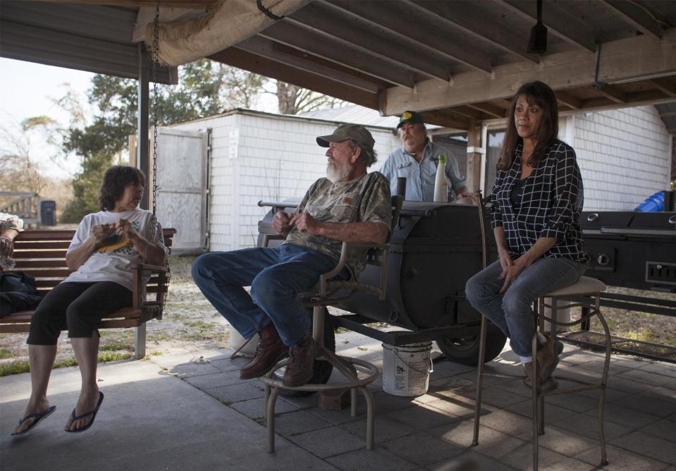 Flemington Road community neighbors from left, Pat Malpass,, Sam Malpass, Kenneth Sandlin and Sue Bouchard of Wilmington, North Carolina, talk at the home of Pat and Sam Malpass on Wednesday, Feb. 19, 2014. The neighbors of the small community nearby the L.V. Sutton Complex operated by Duke Energy feel the plant could be polluting well water with spill off and seepage from large coal ash ponds nearby their only water source. (AP Photo/Randall Hill)