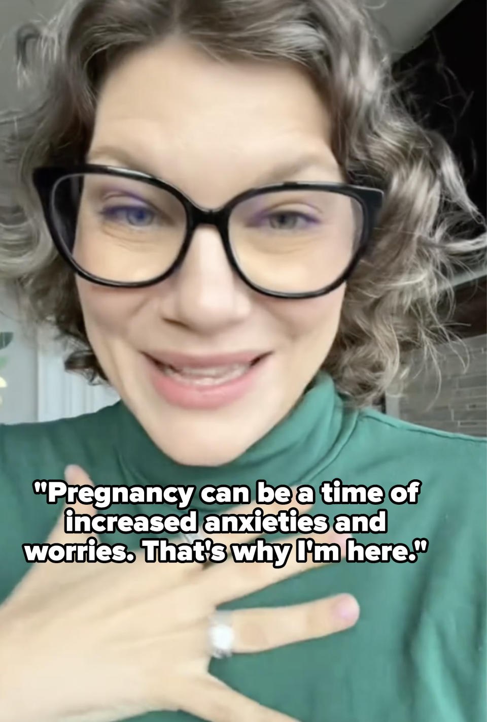 Woman with glasses smiling, wearing a green top, with caption: "Pregnancy can be a time of increased anxieties and worries; that's why I'm here"