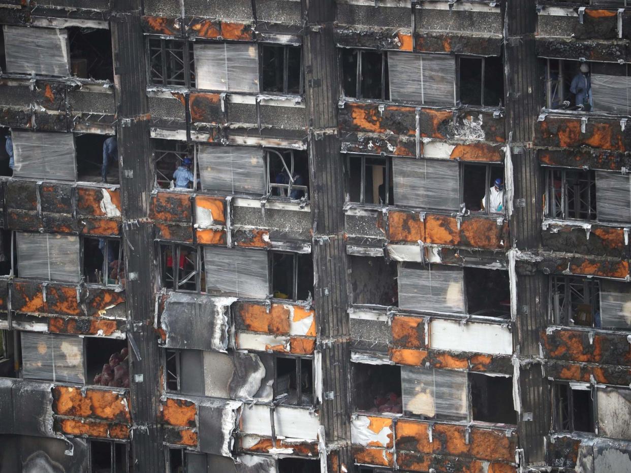 Workers stand inside the burnt out remains of the Grenfell Tower: REUTERS/Hannah Mckay