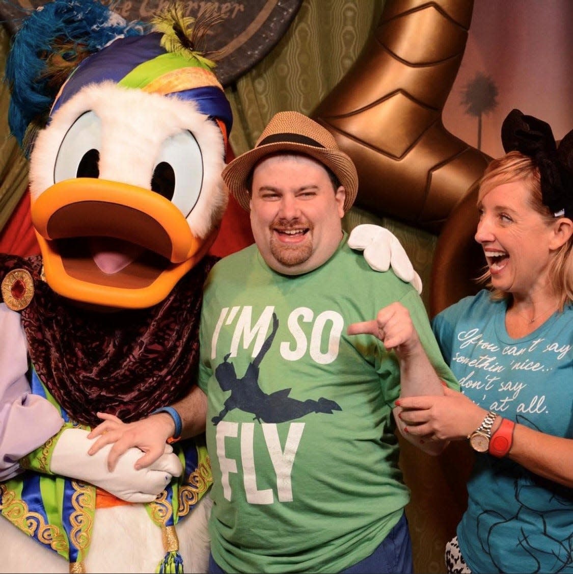 Tami Hill, right, looks on with a smile as her younger brother, Patrick, who has severe and profound disabilities, meets Donald Duck at Walt Disney World.