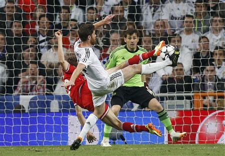 Real Madrid's Sergio Ramos challenges Bayern Munich's Thomas Muller during their Champions League semi-final first leg soccer match at Santiago-Bernabeu stadium in Madrid April 23, 2014. REUTERS/Sergio Perez