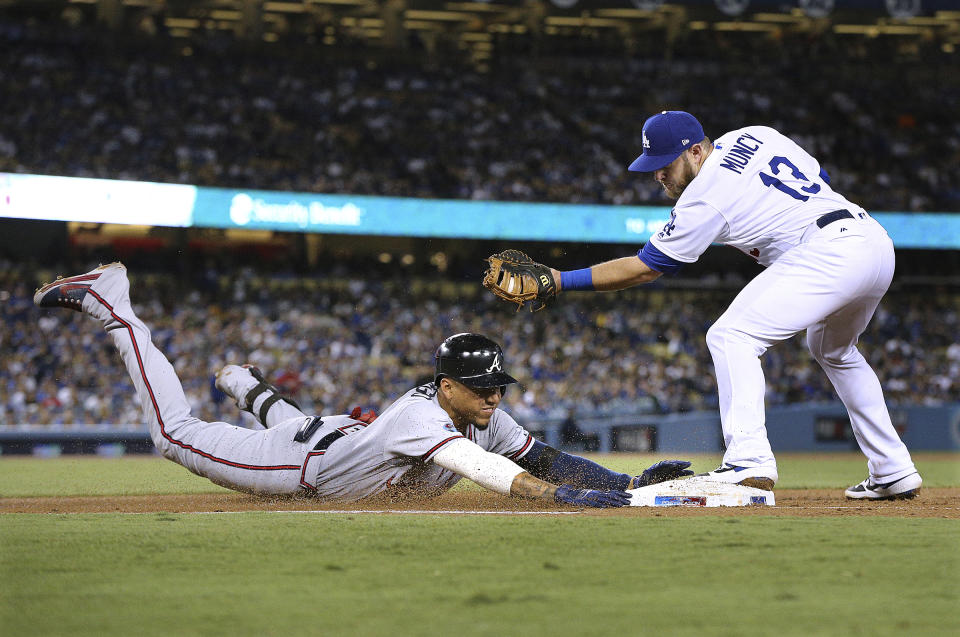 Atlanta Braves' Johan Camargo is put out at first base by Los Angeles Dodgers' Max Muncy on a ground ball to Clayton Kershaw during the fourth inning of Game 2 of a baseball National League Division Series, Friday, Oct. 5, 2018, in Los Angeles. (Curtis Compton/Atlanta Journal Constitution via AP)