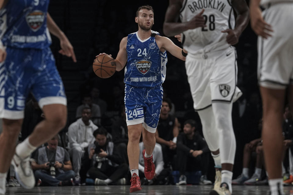 Maccabi Ra'anana's Eidan Alber, center, dribbles upcourt during a preseason NBA basketball game against the Brooklyn Nets, Thursday, Oct. 12, 2023, in New York. (AP Photo/Bebeto Matthews)