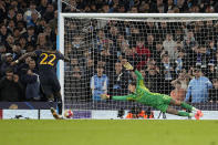 Manchester City's goalkeeper Ederson, right, fails to save the ball as Real Madrid's Antonio Rudiger scores the winning penalty during a penalty shootout during the Champions League quarterfinal second leg soccer match between Manchester City and Real Madrid at the Etihad Stadium in Manchester, England, Wednesday, April 17, 2024. (AP Photo/Dave Shopland)