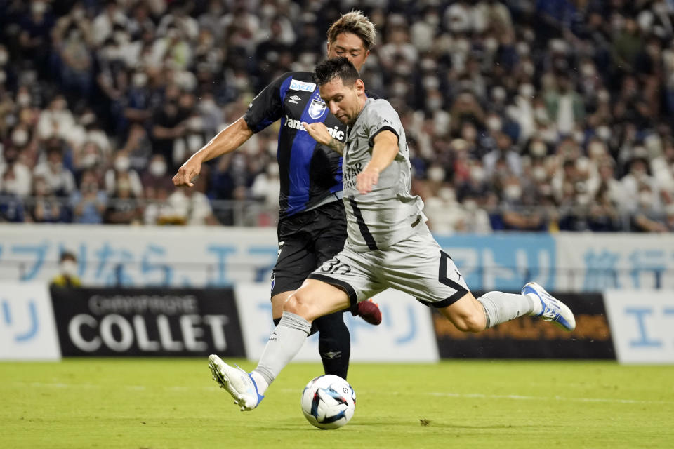 FILE - Paris Saint-Germain's Lionel Messi kicks the ball as Gamba Osaka's Genta Miura tires to defend during a friendly soccer match between Paris Saint-Germain and Gamba Osaka in Suita, western Japan, on July 25, 2022. (AP Photo/Hiro Komae, File)