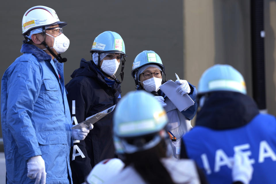 International Atomic Energy Agency Director General Rafael Mariano Grossi, second left, is guided at a facility for sampling treated and diluted radioactive water at the Fukushima Daiichi nuclear power plant, operated by Tokyo Electric Power Company Holdings (TEPCO), in Futaba town, northeastern Japan, Wednesday, March 13, 2024. (AP Photo/Eugene Hoshiko, Pool)