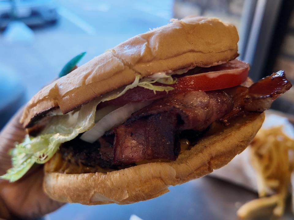 hand holding up a burger at kopps in Wisconsin