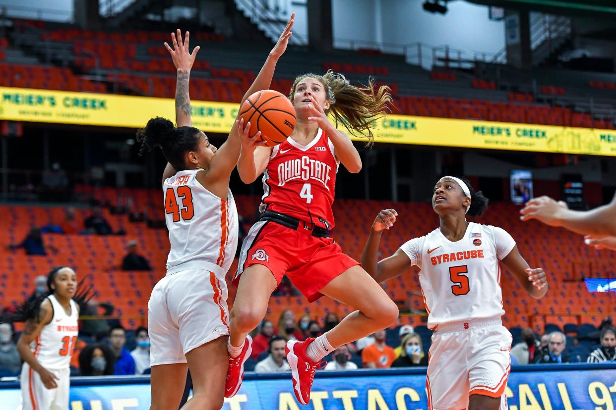 Ohio State guard Jacy Sheldon (4) drives to the basket between Syracuse guard Christianna Carr (43) and guard Teisha Hyman (5) during the first half of an NCAA college basketball game in Syracuse, N.Y., Wednesday, Dec. 1, 2021. (AP Photo/Adrian Kraus)