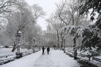 <p>Pedestrians walk through the park at City Hall in New York City as a spring storm hit the Northeast with strong winds and a foot or more of snow expected in some parts of the region on Wednesday, March 21, 2018. (Photo: Gordon Donovan/Yahoo News) </p>