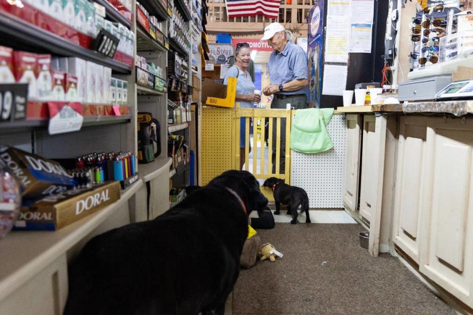 Hansel Carter speaks with a customer at Mr. Bunky’s Market, in Eastover, South Carolina on Tuesday, June 18, 2024. His dogs, Gretel and Tippy, sleep and play behind the cash register.