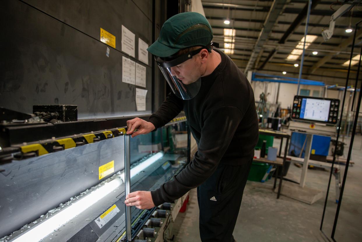 EBBW VALE, WALES, - SEPTEMBER 25:  A general view of a member of staff at Cwmtillery Glass factory placing a spacer on the units before being filled with argon gas and sealed as a unit on September 25, 2020 in Ebbw Vale, Wales United Kingdom. (Photo by Huw Fairclough/Getty Images)