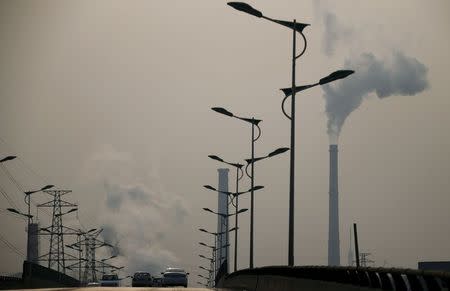 Smoke rises from chimneys of a steel plant next to a viaduct on a hazy day in Tangshan, Hebei province in this February 18, 2014 file photo. REUTERS/Petar Kujundzic/Files