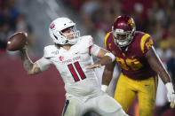 FILE - In this Sept. 31, 2019, file photo, Fresno State quarterback Jorge Reyna, left, looks to throw a pass as Southern California USC Trojans defensive lineman Christian Rector approaches during an NCAA college football game in Los Angeles. The NCAA’s Board of Governors is urging Gov. Gavin Newsom not to sign a California bill that would allow college athletes to receive money for their names, likenesses or images. In a six-paragraph letter to Newsom, the board said the bill would give California schools an unfair recruiting advantage. As a result, the letter says, the NCAA would declare those schools ineligible for its events. (AP Photo/Kyusung Gong, File)