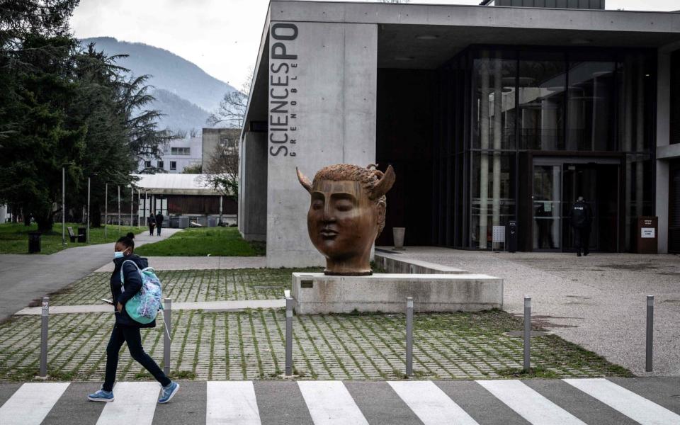 A student walks past the entrance of the Sciences-Po Grenoble's campus, in Saint-Martin-d'Heres, near Grenoble, south eastern France -  JEAN-PHILIPPE KSIAZEK/AFP