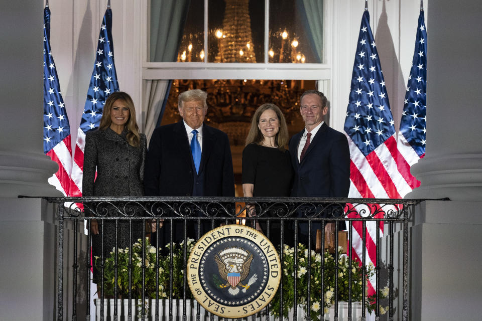 President Donald Trump, first lady Melania Trump, and Amy Coney Barrett and her husband Jesse stand on the Blue Room Balcony after Supreme Court Justice Clarence Thomas administered the Constitutional Oath to her on the South Lawn of the White House White House in Washington, Monday, Oct. 26, 2020. Barrett was confirmed to be a Supreme Court justice by the Senate earlier in the evening. (AP Photo/Alex Brandon)