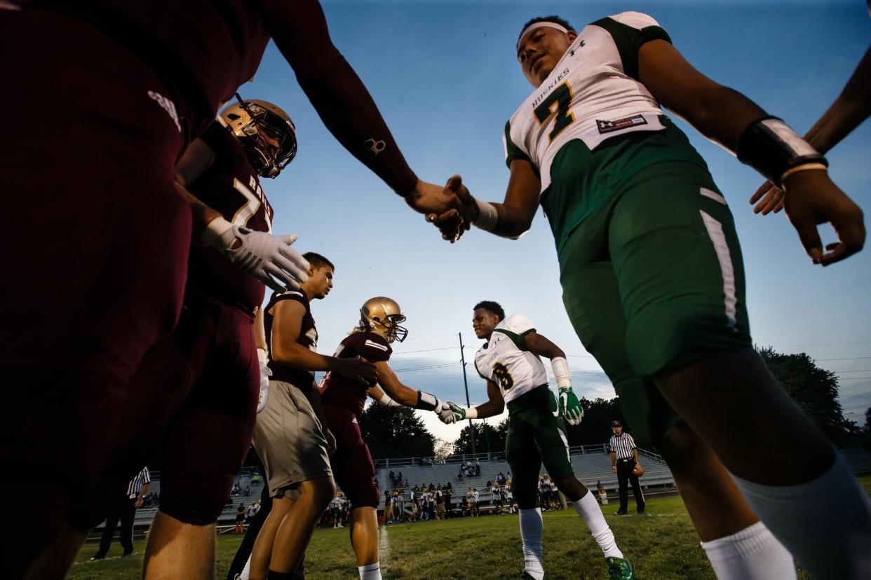 Hoover's Byron Jarrett (7), and Hoover's Domique Wright (8) shake hands with the Lincoln captains before their football game against Hoover at home on Sept. 15, 2017, in Des Moines.