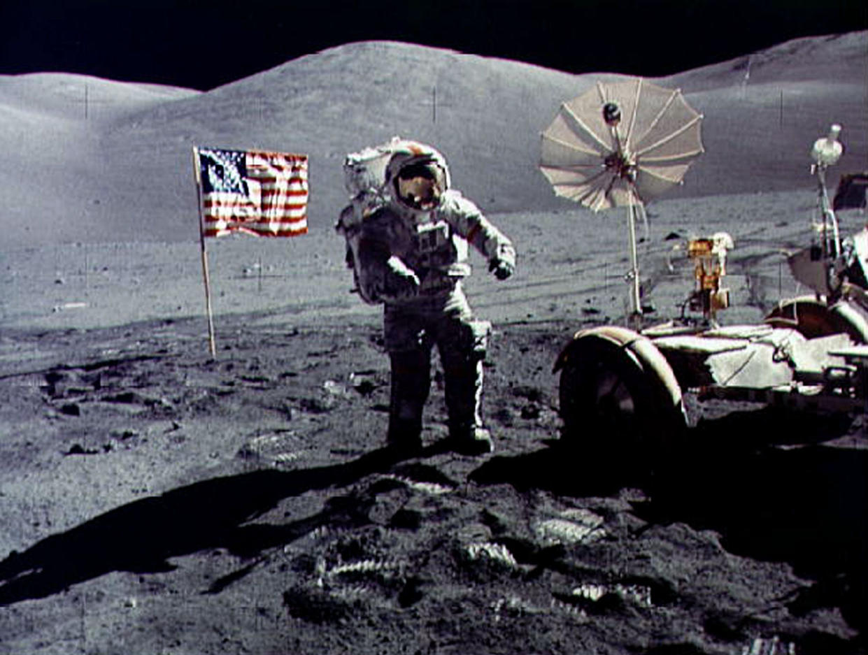 - FILE PHOTO DECEMBER 1972 - Twenty-five years ago tomorrow, on December 19, 1972, humans returned from another celestial body for the last time following the last Apollo mission. In this file photo, astronaut Eugene Cernan walks toward the Lunar Roving Vehicle (LRV) near the U.S. flag at the Taurus-Littrow landing site of Apollo 17. The photograph was taken by astronaut Harrison H. Schmitt, lunar module pilot. Cernan was the last human being to step on the moon as he was entered the Lunar Module after Schmitt for the return flight to earth.   ? QUALITY DOCUMENT