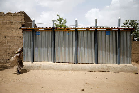 A girl walks past a toilet place set up at the IDP camp at Banki, Borno, Nigeria April 26, 2017. REUTERS/Afolabi Sotunde