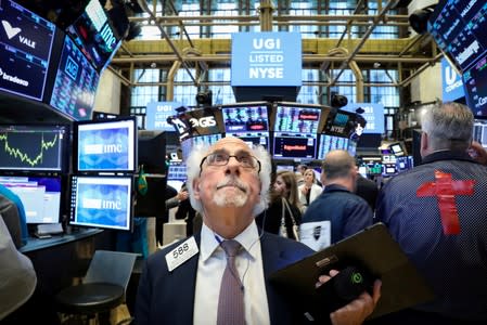 FILE PHOTO: Traders work on the floor at the NYSE in New York