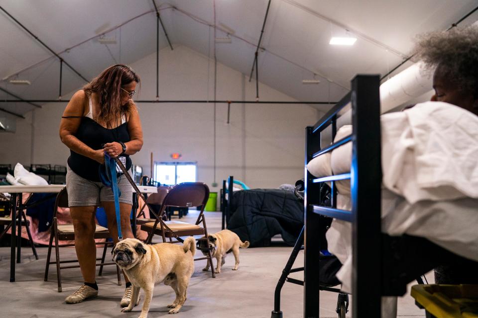 Ann Paskwietz brings her dogs inside the Respiro structure at Human Services Campus on Saturday, June 4, 2022, in Phoenix. The structure offers unhoused residents an enclosed air-conditioned area with a hundred beds.