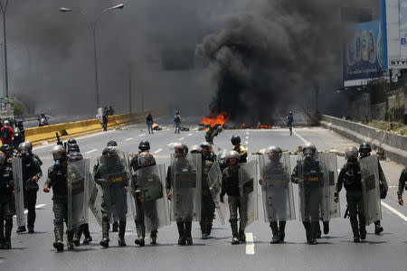 Riot police take position as demonstrators rally against Venezuela's President Nicolas Maduro's government in Caracas. REUTERS/Carlos Garcia Rawlins