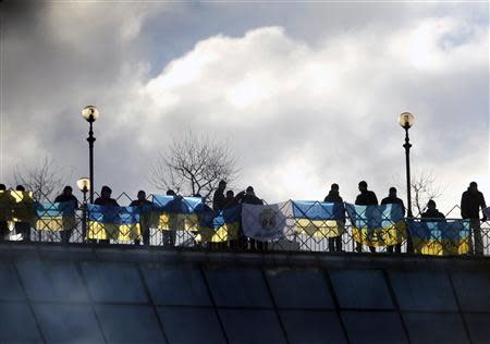 Pro-European integration protesters with Ukrainian flags look out over Independence Square in Kiev December 14, 2013. REUTERS/Vasily Fedosenko