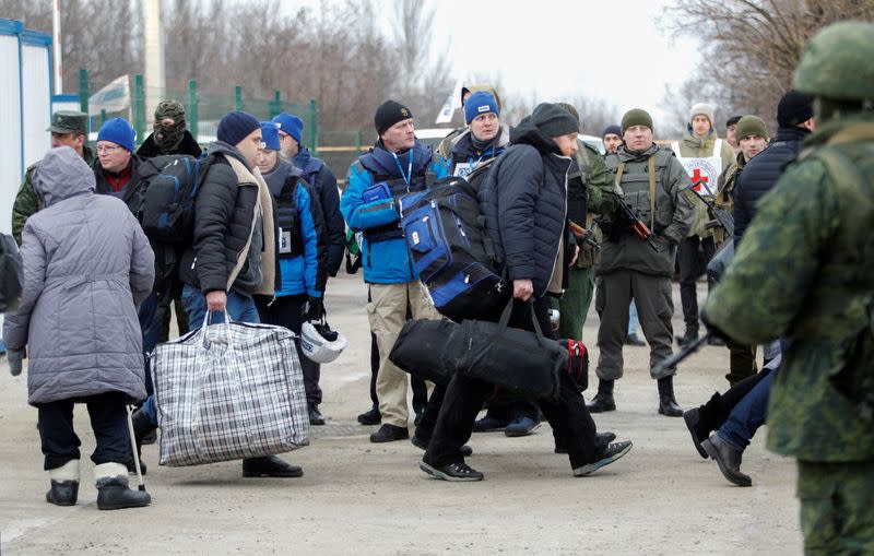 Men carry their belongings after they were released exchanged during a prisoners of war swap between Ukraine and the separatist republics in Donetsk region