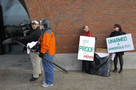 Demonstrators (R) asserting that evidence of the Boston Marathon bombing was fabricated stand outside the federal courthouse ahead of a pre-trial conference for Boston Marathon bombing suspect Dzhokhar Tsarnaev in Boston, Massachusetts December 18, 2014. REUTERS/Brian Snyder