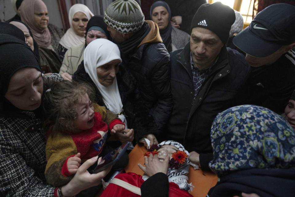 Mourners take a last look at the body of Mohammad Khadour, 17, at the family house during his funeral in the West Bank village of Biddu, southwest of Ramallah, Monday, Feb. 12, 2024. Khdour, a U.S. citizen born in Florida, was shot Saturday while driving with a cousin on a hillside by what his family alleges was Israeli fire. (AP Photo/Nasser Nasser)