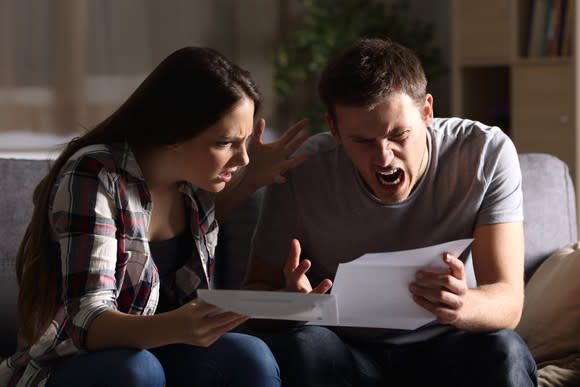 An enraged couple looking at a bill.