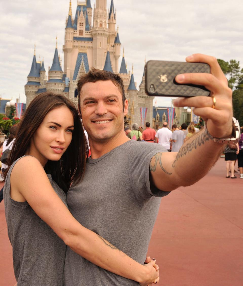 Megan Fox and Brian Austin Green take a photo in front of Cinderella Castle at Disney World.