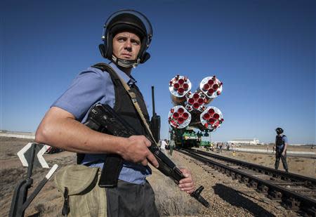 Russian policemen guard the Soyuz TMA-19 spacecraft as it is transported to its launch pad at Baikonur cosmodrome June 13, 2010. REUTERS/Shamil Zhumatov