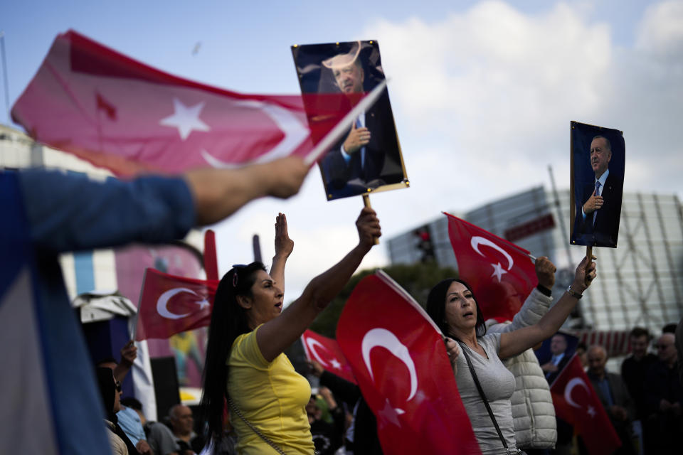 Supporters of Turkish President and People's Alliance's presidential candidate Recep Tayyip Erdogan dance as they give handouts to commuters in Istanbul, Turkey, Tuesday, May 23, 2023. Two opposing visions for Turkey’s future are on the ballot when voters return to the polls Sunday for a runoff presidential election, which will decide between an increasingly authoritarian incumbent President Recep Tayyip Erdogan and challenger Kemal Kilicdaroglu, who has pledged to restore democracy. (AP Photo/Francisco Seco)