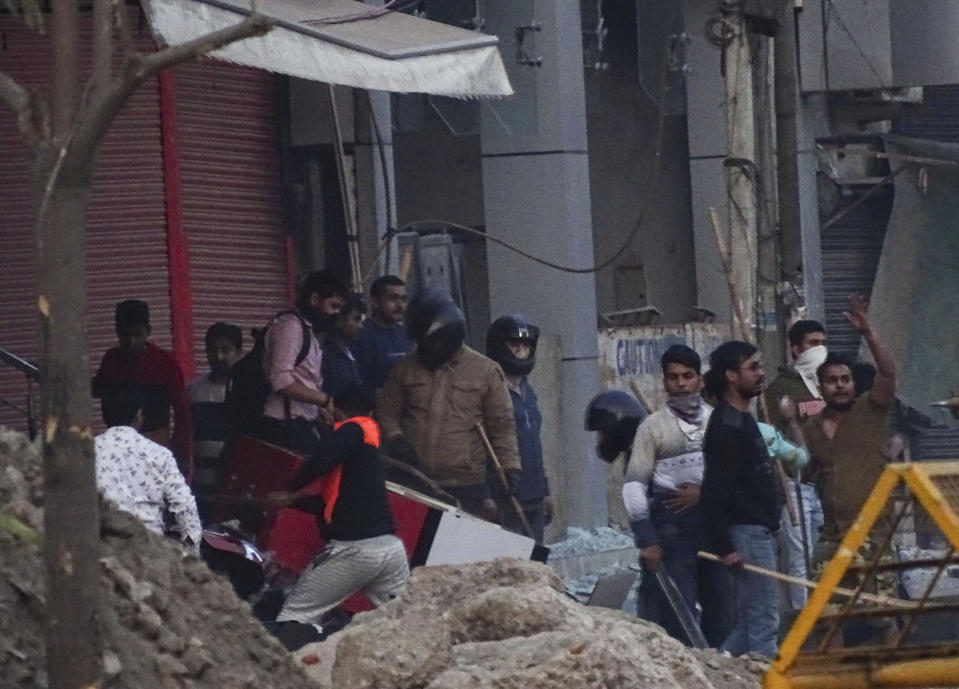 A mob vandalizes a shop during violence between two groups in New Delhi, India, Tuesday, Feb. 25, 2020. At least 10 people were killed in two days of clashes that cast a shadow over U.S. President Donald Trump's visit to the country. (AP Photo)