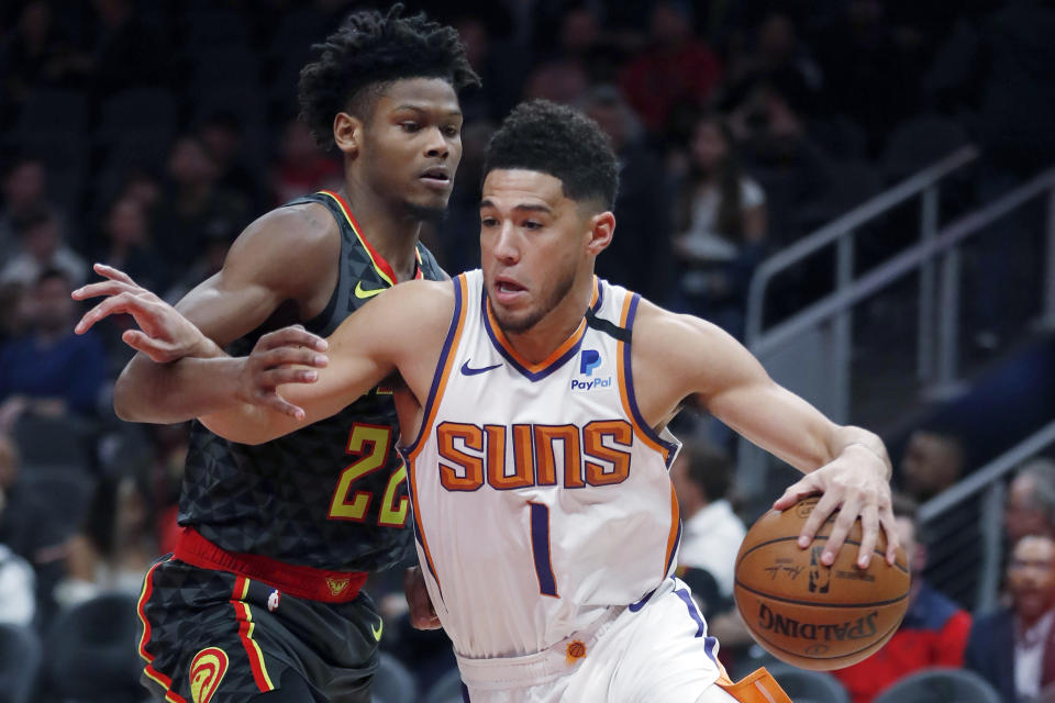 Phoenix Suns guard Devin Booker (1) drives against Atlanta Hawks forward Cam Reddish (22) in the first half of an NBA basketball game Tuesday, Jan. 14, 2020, in Atlanta. (AP Photo/John Bazemore)