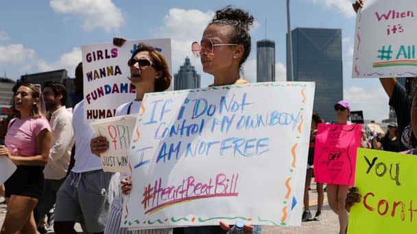 PHOTO: Demonstrators hold signs while marching during a protest against Georgia's 'heartbeat' abortion bill in Atlanta, Georgia, May 25, 2019. The bill bans abortion after a doctor can detect a fetal heartbeat, usually around the sixth week of pregnancy. (Bloomberg via Getty Images, FILE)
