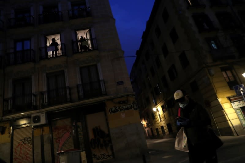 Spanish blues singer "Betta" sings from her balcony next to guitar player Capalbo during a daily evening concert to support health workers and to make it easier for her neighbours to bear the coronavirus lockdown in Madrid