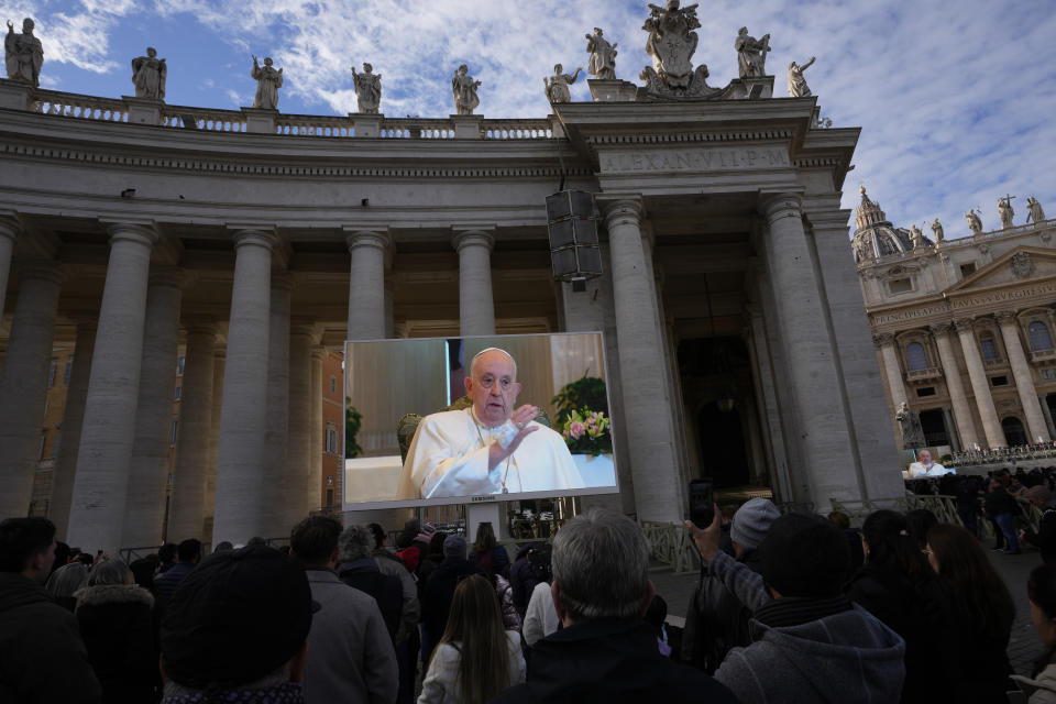 Pope Francis appears on a giant monitor set up in St. Peter's Square at The Vatican, Sunday, Nov. 26, 2023, as he blesses the faithful gathered in the square for the traditional Angelus noon prayer. On Saturday, the Vatican said the pope, whose 87th birthday is next month, was taken to a Rome hospital to have a CT scan to rule out pulmonary complications following a light flu, and that the exam was negative. (AP Photo/Alessandra Tarantino)