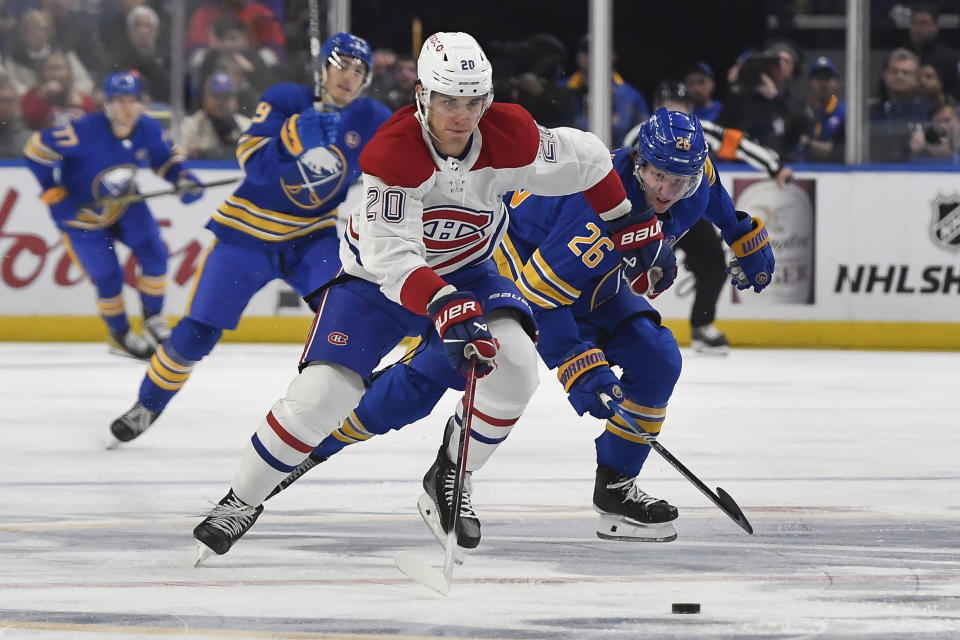 Montreal Canadiens left wing Juraj Slafkovsky (20) skates the puck way from Buffalo Sabres defensemen Rasmus Dahlin during the first period of an NHL hockey game in Buffalo, N.Y., Monday, Oct. 23, 2023. (AP Photo/Adrian Kraus)