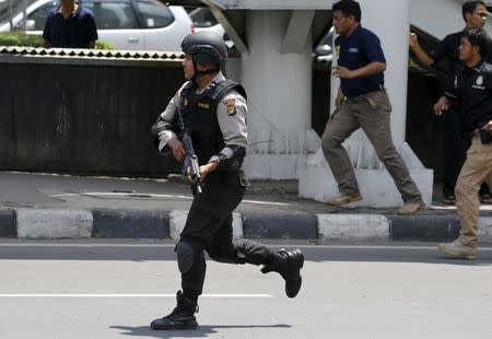 An Indonesian policeman runs near the site of a blast in Jakarta, Indonesia, January 14, 2016. REUTERS/Beawiharta