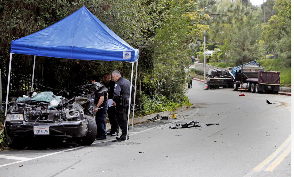 Police investigate the scene of a fatal police car accident, Friday, March 7, 2014 in Beverly Hills, Calif. A veteran Los Angeles police officer was killed and his rookie partner was critically injured Friday when their patrol car collided with a big rig on a residential street. The truck driver also was injured. (AP Photo/Los Angeles Times, Francine Orr, Pool)