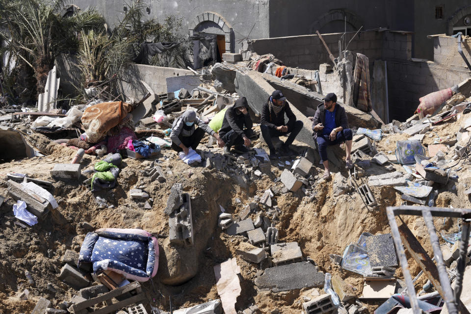 Palestinians look at destruction after an Israeli airstrike on a residential building of the Ganan family in Deir al Balah, Gaza Strip, Thursday, March 7, 2024. (AP Photo/Adel Hana)