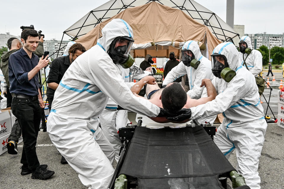 Workers in protective suits and gas masks put a man on the stretcher during exercises to practise for a an accident at the Zaporizhzhia Nuclear Power Plant, in Zaporizhzhia, southern Ukraine, June 29, 2023. / Credit: Dmytro Smolienko/Ukrinform/Future Publishing/Getty
