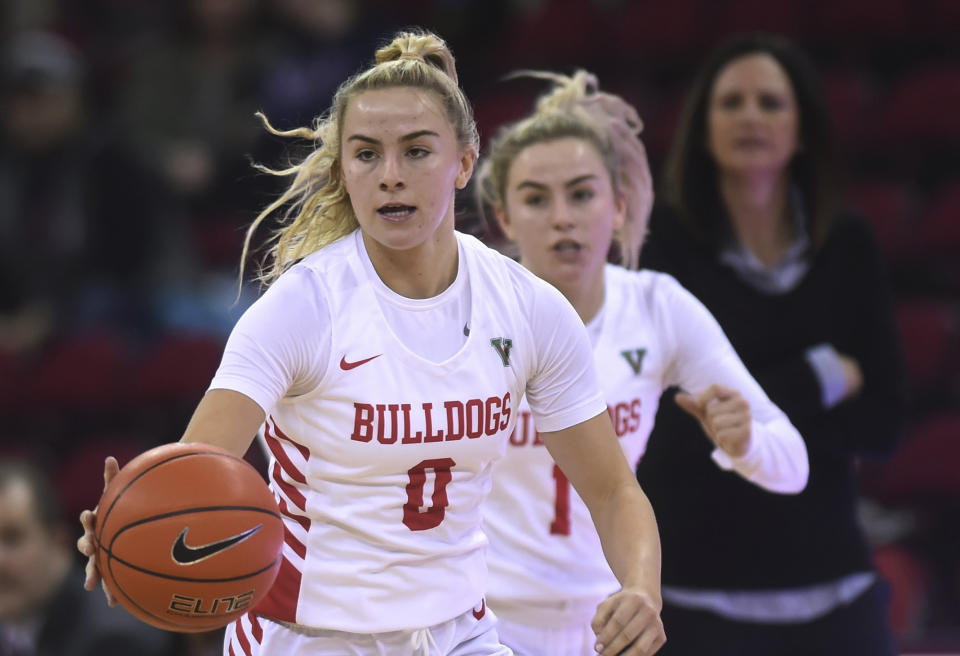 Fresno State's Hanna Cavinder, left, with sister Haley Cavinder, center, and head coach Jaime White, background right, in the game against UC Merced on Dec. 28, 2019, in Fresno, Calif. It is a man's world six months after the NCAA cleared the way for college athletes to earn money on their celebrity. Men lead the way in total name, image and likeness compensation and have more NIL activities than women. (Eric Paul Zamora/The Fresno Bee via AP)/The Fresno Bee via AP)