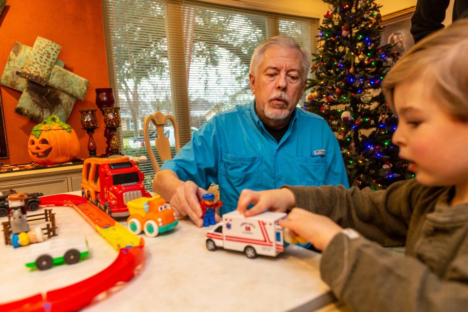 For a story on parents trying to keep grandparents holiday spending in check, we photograph, Andrew Herzog (black sweater), his father Chris Herzog (Blue Shirt), and son Patrick (3 years old). Grandfather Chris often babysits Patrick..Photos taken at the home of grandfather, Chris Herzog, who resides in Dallas, Texas. The three were playing with some transportation themed toys on the dining room table which became an imaginary race track.