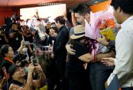 A supporter hugs Future Forward Party leader Thanathorn Juangroongruangkit as he arrives to give a speech, at the party's headquarters in Bangkok