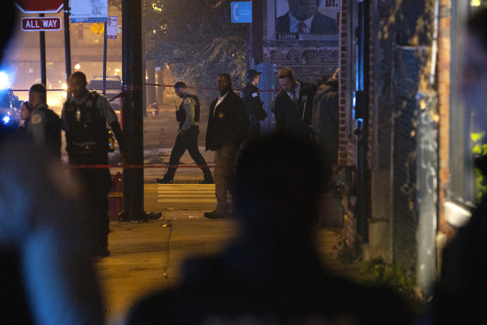 Chicago police work at the scene of a mass shooting near Polk Street and California Avenue on the city's West Side on Monday, Oct. 31, 2022. Chicago Police say several people were injured in a drive-by shooting Halloween night, including three children (E. Jason Wambsgans /Chicago Tribune via AP)